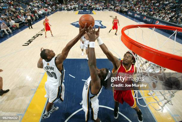 Darrell Arthur and DeMarre Carroll of the Memphis Grizzlies fight for a rebound against Jordan Hill of the Houston Rockets on April 06, 2010 at...