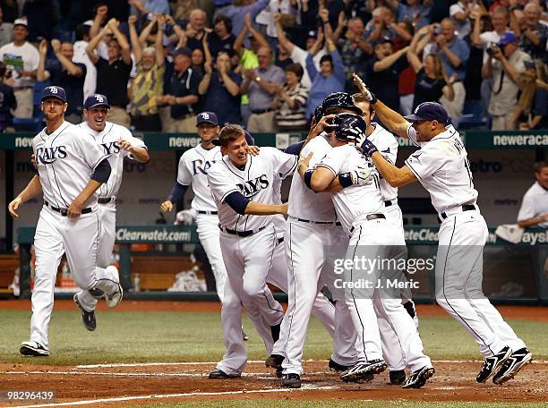 Pinch hitter Kelly Shoppach of the Tampa Bay Rays is mobbed by his teammates after he scored the winning run against the Baltimore Orioles during the...