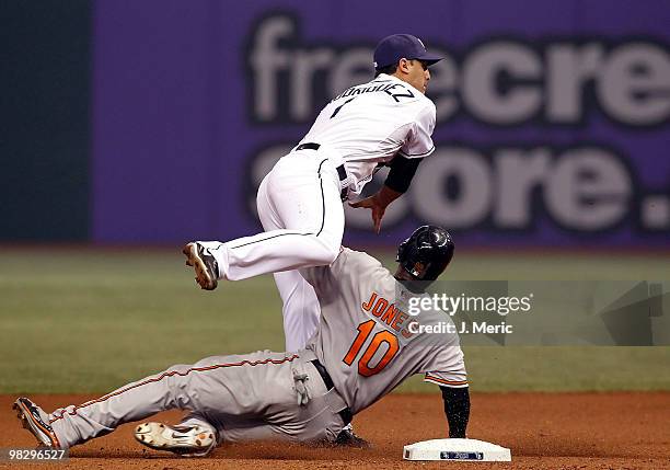 Infielder Sean Rodriguez of the Tampa Bay Rays turns a double play as outfielder Adam Jones of the Baltimore Orioles attempts to break it up during...