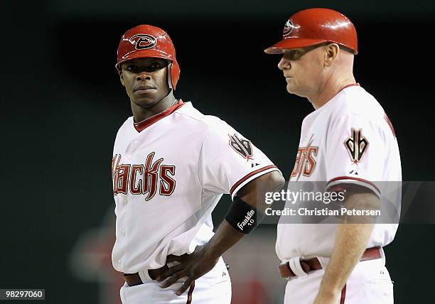 Justin Upton of the Arizona Diamondbacks stands with first base coach Matt Williams after hitting a RBI single against the San Diego Padres during...