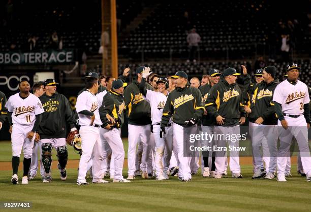 Mark Ellis is congratulated by teammates after Ellis got the game-winning hit in the tenth inning against the Seattle Mariners at the Oakland-Alameda...