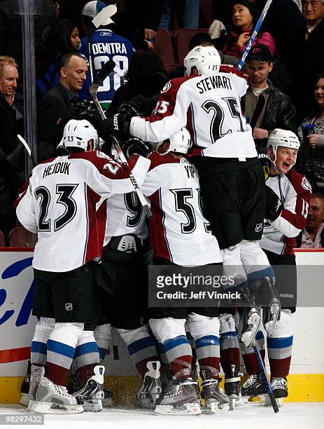 Chris Stewart of the Colorado Avalanche jumps on his teammates as he celebrates their win in the shootout during their game against the Vancouver...