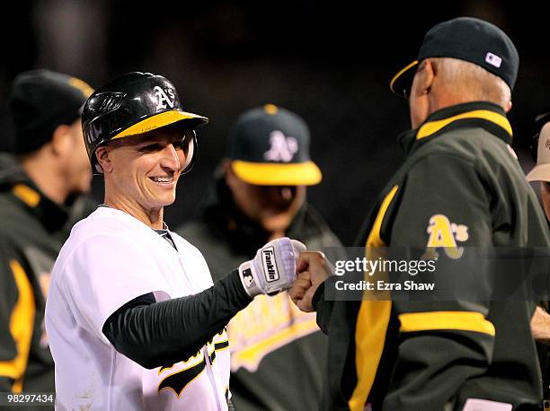 Mark Ellis is congratulated by teammates after Ellis got the game-winning hit in the tenth inning against the Seattle Mariners at the Oakland-Alameda...