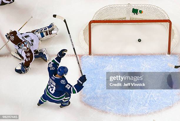 Craig Anderson of the Colorado Avalanche looks on as Henrik Sedin of the Vancouver Canucks celebrates a Vancouver goal during their game at General...
