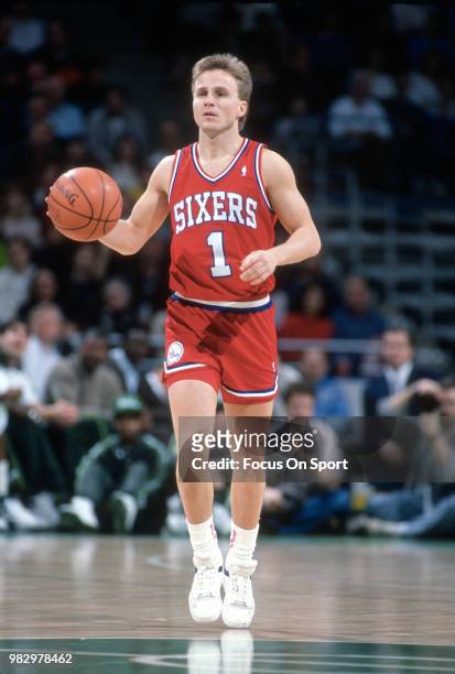 Scott Brooks of the Philadelphia 76ers dribbles the ball against the Milwaukee Bucks during an NBA basketball game circa 1990 at Bradley Center in...