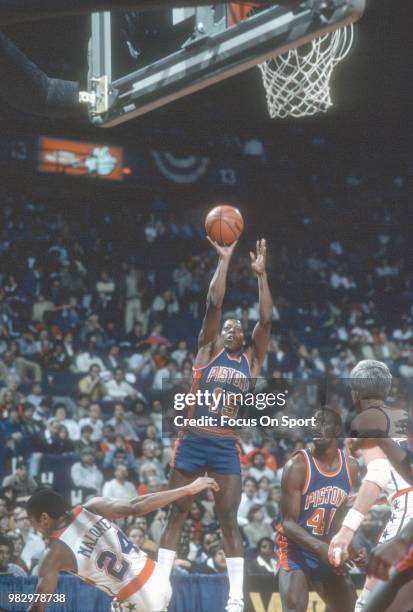 Vinnie Johnson of the Detroit Pistons shoots over Jeff Malone of the Washington Bullets during an NBA basketball game circa 1983 at the Capital...