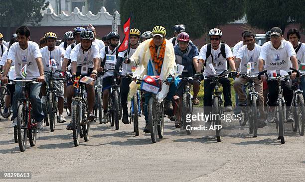 Nepalese cyclist Pushkar Shah holds a Nepalese flag as he cycles with supporters in Kathmandu on April 7 as he prepares to leave for Mount Everest...