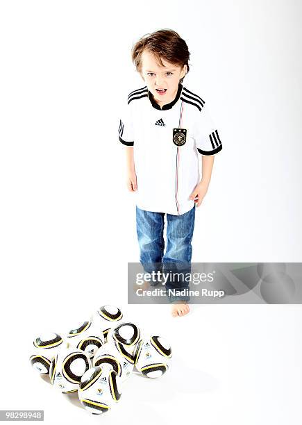 Germany fan child Aurele Rupp poses in the original german national trikot with World Cup 2010 mini ball Jabulani during a photo session on March 6,...