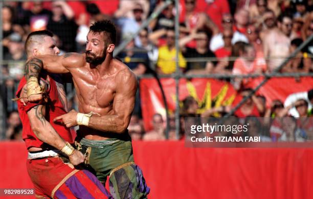 Players compete during the final match of the Calcio Storico Fiorentino on Piazza Santa Croce in Florence on June 24, 2018.