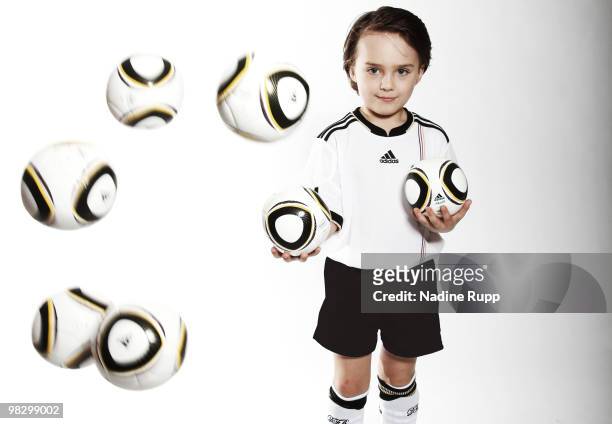 Germany fan child Aurele Rupp poses in the original german national trikot with World Cup 2010 mini ball Jabulani during a photo session on March 6,...