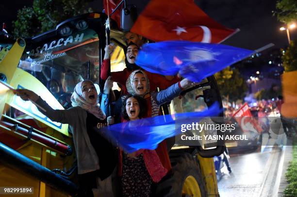 People react and wave flags outside the Justice and Development Party headquarters in Istanbul, on June 24 during the Turkish presidential and...