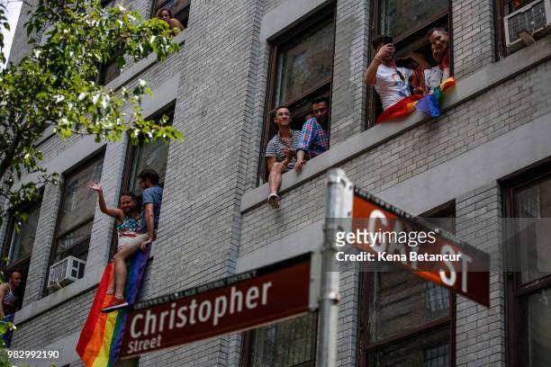 Revellers watch the annual Pride Parade from windows on June 24, 2018 in New York City. The first gay pride parade in the U.S. Was held in Central...