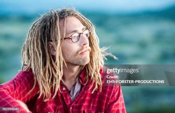 man in his twenties with long blonde dreadlocks - dreadlocks stockfoto's en -beelden