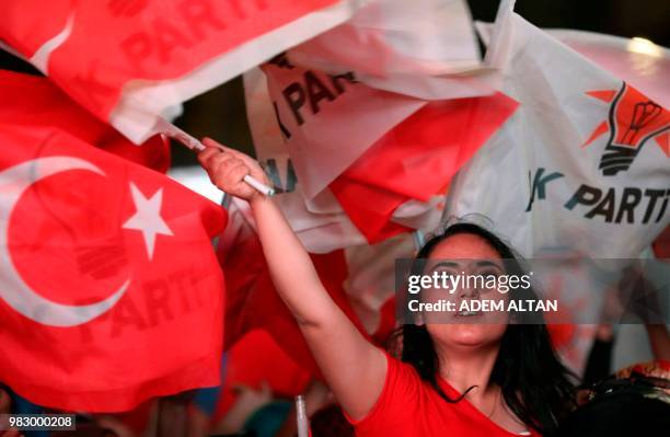 Party supporters wave flags in front of the AKP headquarters in Ankara on June 24 during the Turkish presidential and parliamentary elections. -...