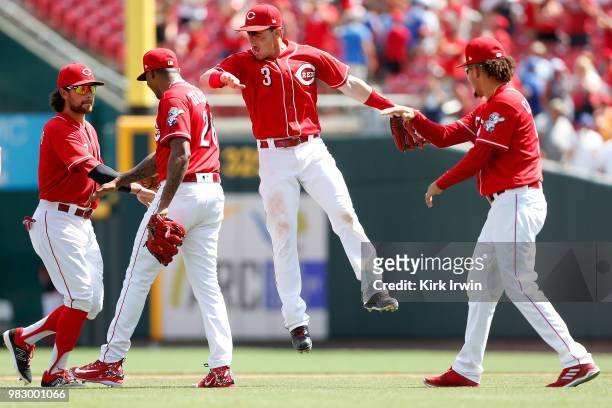Scooter Gennett of the Cincinnati Reds congratulates Raisel Iglesias after defeating the Chicago Cubs 8-6 at Great American Ball Park on June 24,...