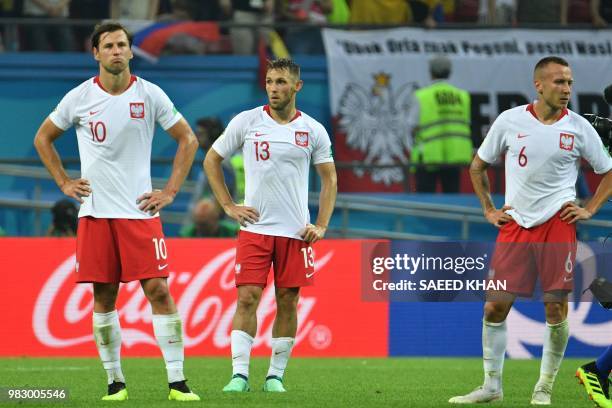 Poland's midfielder Grzegorz Krychowiak, Poland's midfielder Maciej Rybus and Poland's midfielder Jacek Goralski react after being defeated by...