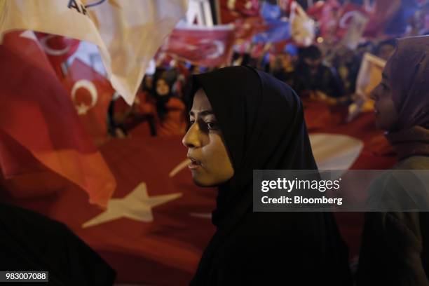 People hold a large Turkish national flag outside of the AKP party headquarters as they react to the outcome of the parliamentary and presidential...