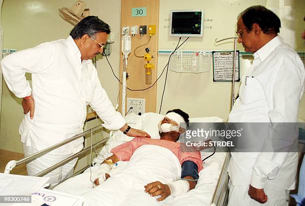 Indian Home Minister P.Chidambaram stands with Chief Minister of the Indian state of Chhattisgarh Raman Singh as they comfort an injured policemen in...