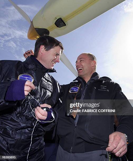 Swiss scientist-adventurer and pilot Bertrand Piccard and test pilot Markus Scherdel reacts after the first test flight of Solar Impulse aircraft, a...