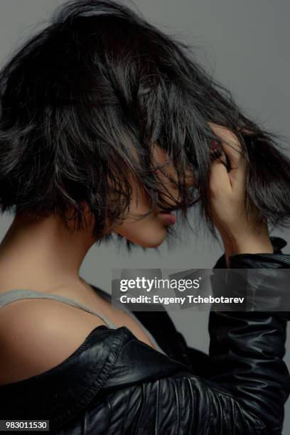 side view of a young woman with her hand in her hair. - hand in hair ストックフォトと画像