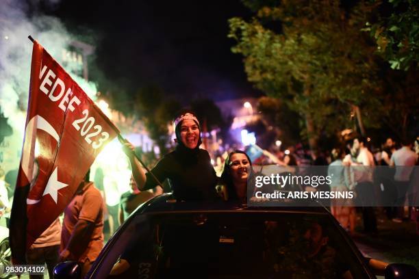 People react and wave Turkish flags outside the Justice and Development Party headquarters in Istanbul, on June 24 during the Turkish presidential...