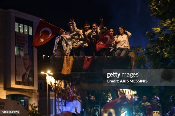 People react and wave Turkish flags outside the Justice and Development Party headquarters in Istanbul, on June 24 during the Turkish presidential...