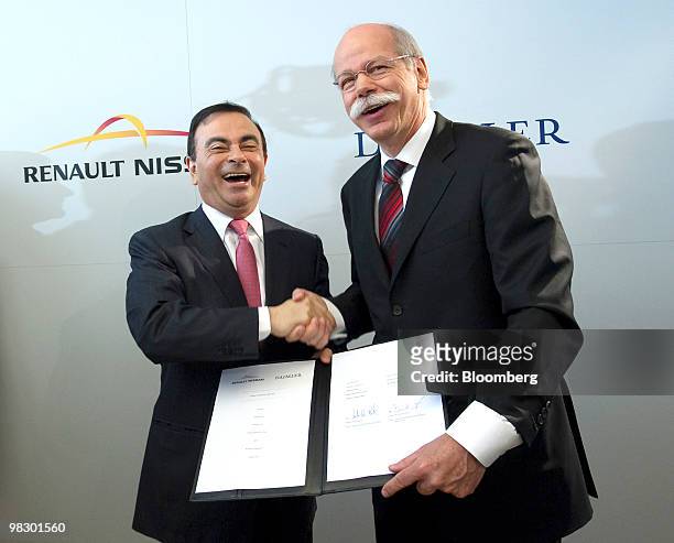 Carlos Ghosn, chief executive officer of Renault SA, left, and Dieter Zetsche, chief executive officer of Daimler AG, shake hands after signing...
