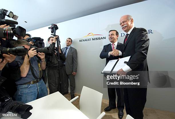 Carlos Ghosn, chief executive officer of Renault SA, center, and Dieter Zetsche, chief executive officer of Daimler AG, right, shake hands after...