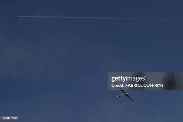 The Solar Impulse aircraft, a pioneering Swiss bid to fly around the world on solar energy is flying under a commercial plane during is first test on...