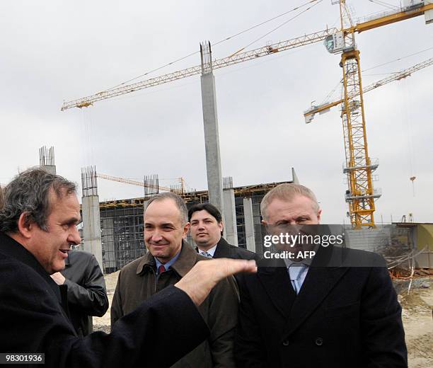 President Michel Platini gestures as Ukrainian Football Federation President Grigory Surkis listens as they inspect the construction site of the Lviv...