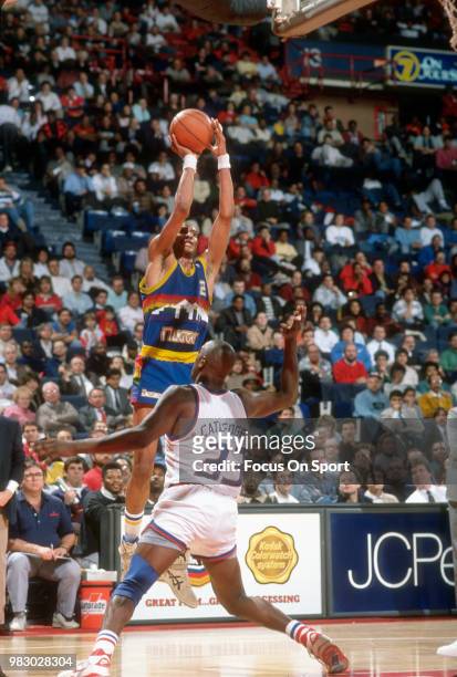 Alex English of the Denver Nuggets shoots over Terry Catledge of the Washington Bullets during an NBA basketball game circa 1989 at the Capital...