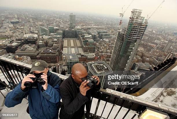 Anders Price and David Lindo of the 'Bird Study Group' use binoculars to observe birds in the City of London from the top of Tower 42 on April 7,...