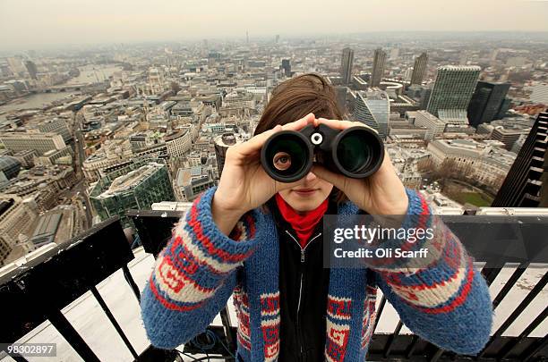 Amity Dunn of the 'Bird Study Group' uses binoculars to observe birds in the City of London from the top of Tower 42 on April 7, 2010 in London,...