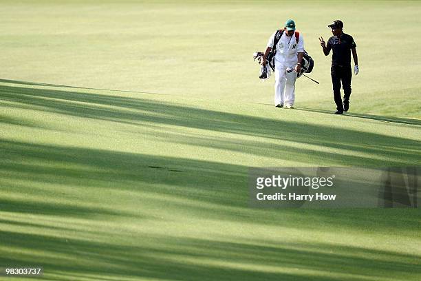 Thongchai Jaidee of Thailand walks with his caddie Surawut Wannapintu during a practice round prior to the 2010 Masters Tournament at Augusta...