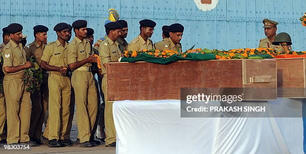 Indian paramilitary Central Reserve Police Force personnel pay tribute in front of the coffins of their fallen comrades during a ceremony at Air...