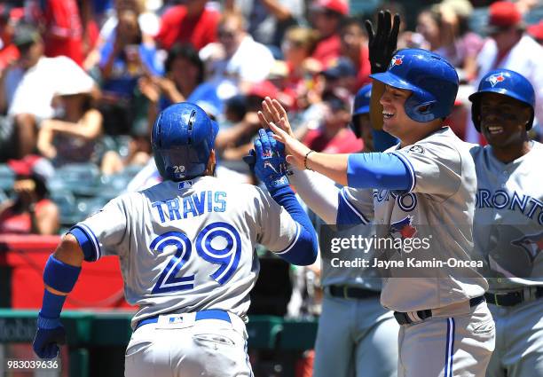 Devon Travis of the Toronto Blue Jays is greeted at home by Justin Smoak, Curtis Granderson and Aledmys Diaz of the Toronto Blue Jays after hitting a...