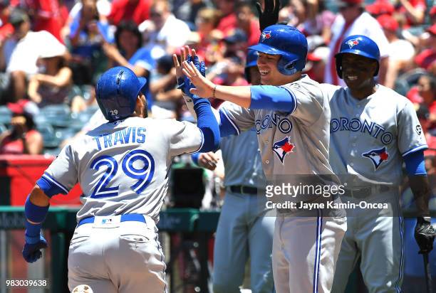 Devon Travis of the Toronto Blue Jays is greeted at home by Justin Smoak, Curtis Granderson and Aledmys Diaz of the Toronto Blue Jays after hitting a...