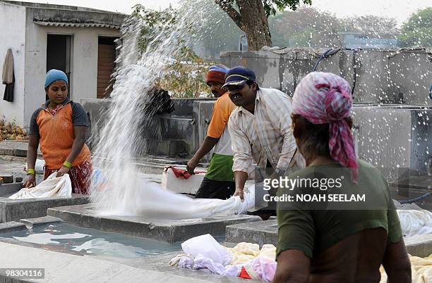 Indian workers locally known as "Dhobiwallahs" wash clothes at Dhobhi Ghat in Hyderabad on March 26, 2010. Dhobiwallahs are the human 'washing...