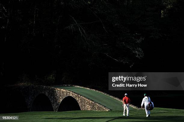 Paul Casey of England and his caddie Christian Donald approach the Hogan Bridge during a practice round prior to the 2010 Masters Tournament at...