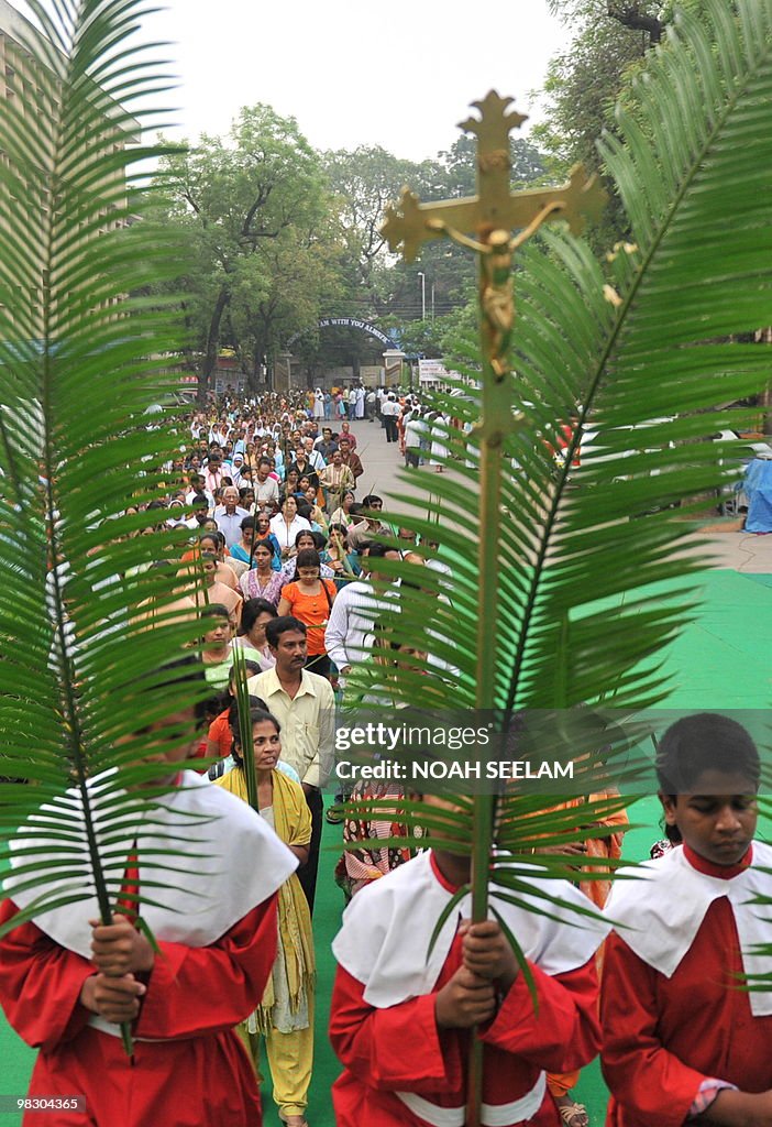 Altar boys hold palm leaves as they part