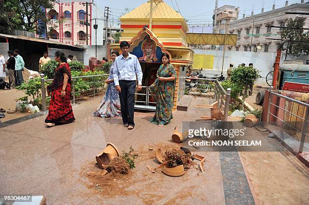 An Indian man inspects broken pots amid destruction at the Hindu temple Shiv Mandir Goshala as communal violence continued in the Sha Ali Banda area...