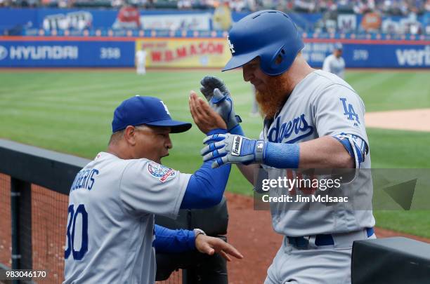Justin Turner of the Los Angeles Dodgers celebrates his eleventh inning home run against the New York Mets with manager Dave Roberts at Citi Field on...