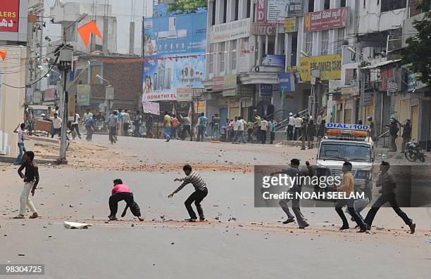 Members of different Indian communities pelt each other with stones in the Sha Ali Banda area of the old city of Hyderabad on March 29, 2010....