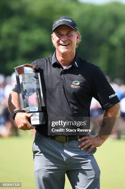 Scott McCarron holds the winners trophy on the 18th green during the third and final round of the American Family Championship at University Ridge...