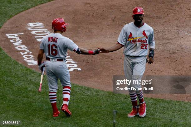 Kolten Wong and Dexter Fowler of the St. Louis Cardinals celebrate after Fowler scored a run in the fifth inning against the Milwaukee Brewers at...