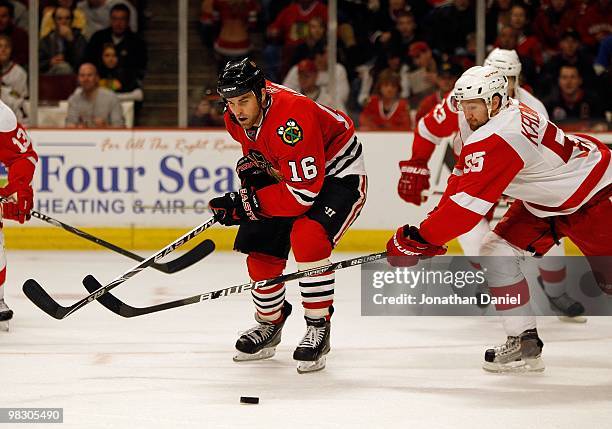 Andrew Ladd of the Chicago Blackhawks moves to the puck as Niklas Kronwall of the Detroit Red Wings defends at the United Center on March 7, 2010 in...