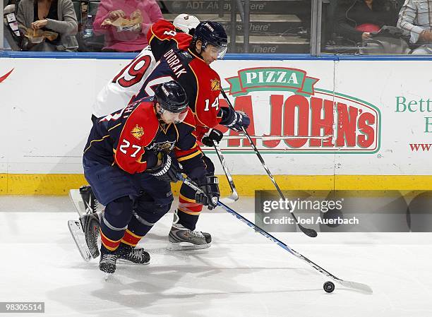 Jason Spezza of the Ottawa Senators is checked off the puck by Radek Dvorak of the Florida Panthers as Steven Reinprecht skates off with the puck on...