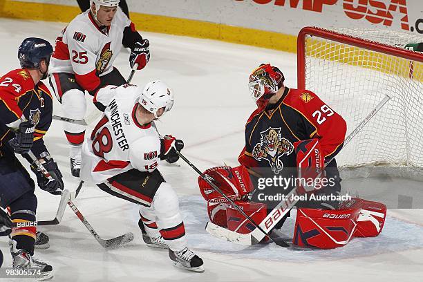 Goaltender Tomas Vokoun of the Florida Panthers stops a shot by Chris Neil with Jesse Winchester of the Ottawa Senators in front of the net waiting...