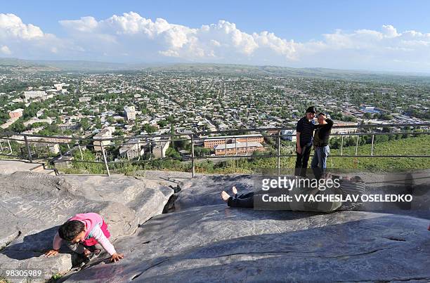 Kyrgyz woman lies on the holy stone at Suleiman-Too mountain in the town of Osh, some 700km outside Bishkek, on May 13, 2009. AFP PHOTO / VYACHESLAV...