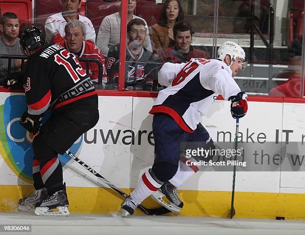 Eric Belanger of the Washington Capitals swipes the puck from the control of Ray Whitney of the Carolina Hurricanes during their NHL game on March...